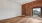a room with a large window and wood flooring
