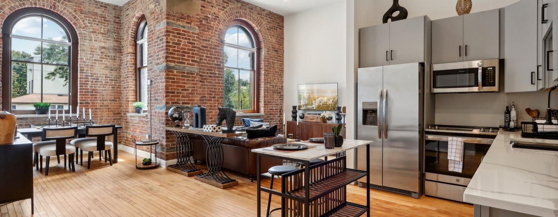 kitchen with stainless steel appliances and living space with large windows
