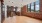 large room with a wood floor and large windows