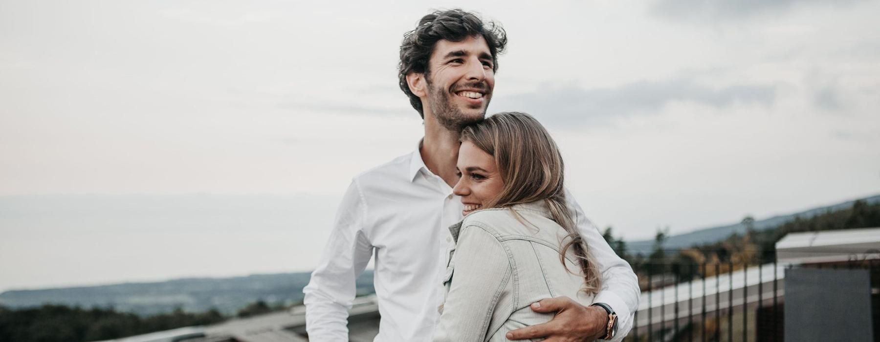 a man and woman hugging on rooftop terrace